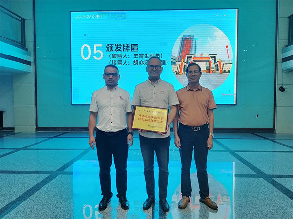 閩發鋁（lǚ）業生產中心副總經理王育生先生（右）向（xiàng）正（zhèng）睿谘詢集團頒發牌匾